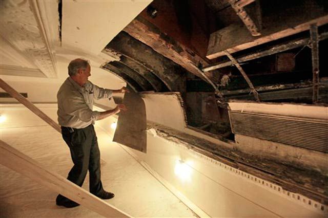 Philip J. Kelly peels away part of the ceiling
